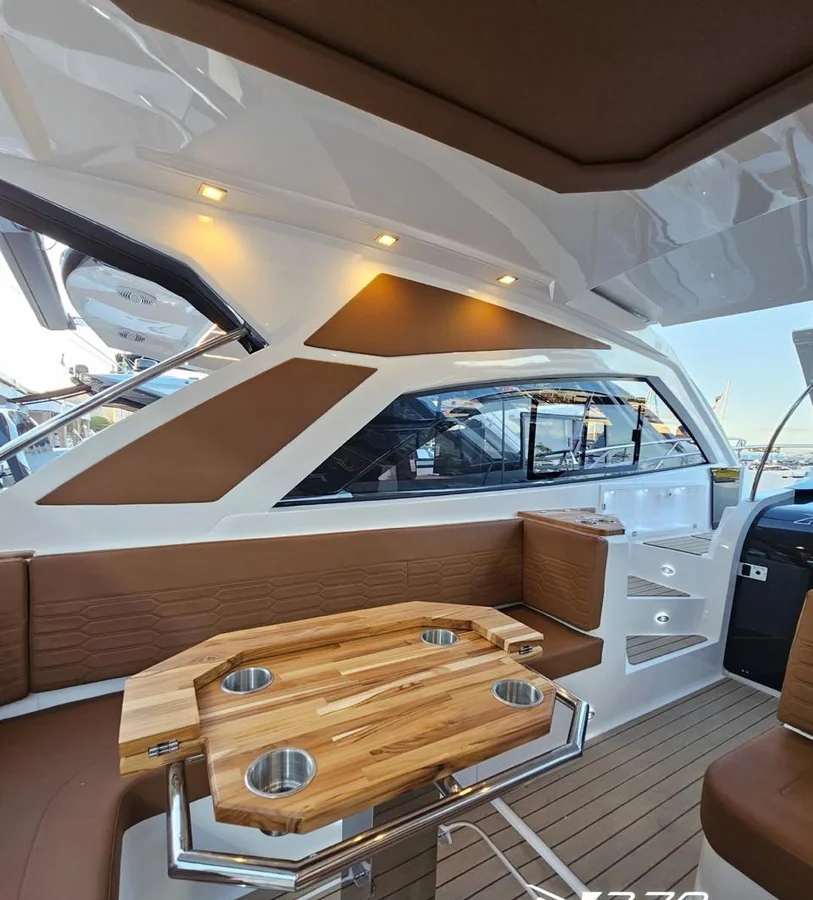 Cockpit da NX370 com mesa de teca e estofados caramelo